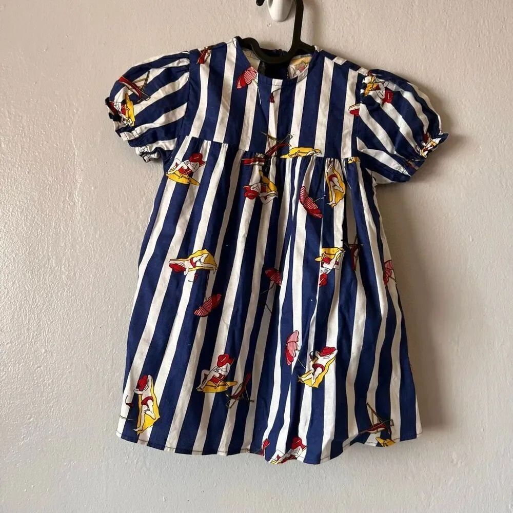 vintage-inspired blue and white striped girl's dress features whimsical illustra